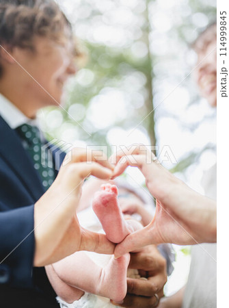 0歳児の息子の足を触る両親 114999845