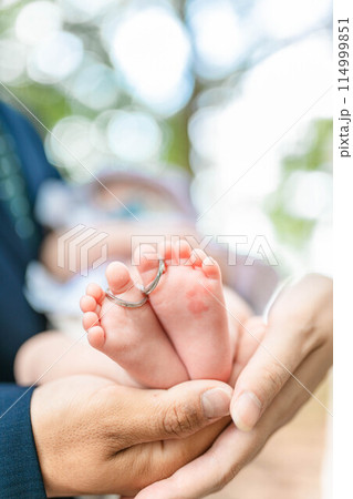 0歳児の息子の足を触る両親 114999851