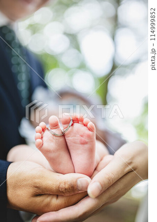 0歳児の息子の足を触る両親 114999852