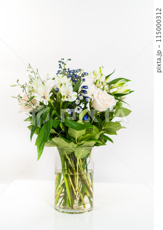 A stunning bouquet featuring fresh white roses and assorted flowers gracefully arranged in a vase, exuding timeless beauty. A stunning bouquet featuring fresh white roses and assorted flowers gracefully arranged in a vase, exuding timeless beauty. 115000312