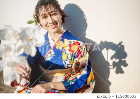 白い花を持っている青い着物の若い女性 115000638