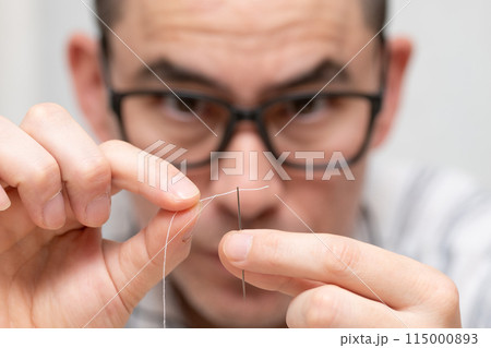 針に糸を通す男性 針に糸を通す男性 115000893
