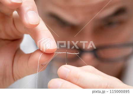 針に糸を通す男性 115000895