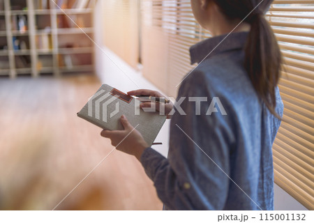 メモ帳を持つ女性 115001132