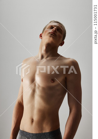 Shirtless handsome young guy posing in underwear shirtless isolated on grey studio background. Perfect muscular body shape Shirtless handsome young guy posing in underwear shirtless isolated on grey studio background. Perfect muscular body shape 115001731