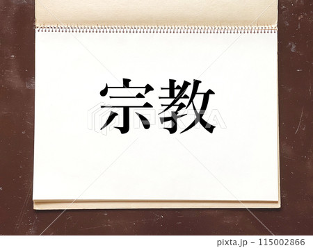 机の上で開いた古いスケッチブックのページ_宗教文字入り 115002866