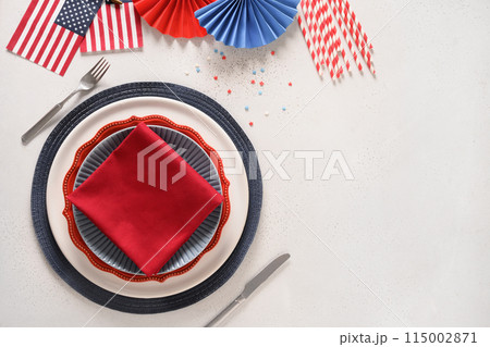 Patriotic table setting with american flag and decoration in national flag colors on white background. Independence Day. Happy Memorial Day. View from above. Copy space. 115002871