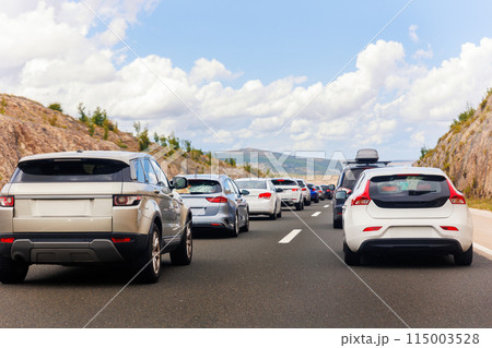 Back tail view of many cars stuck in row at highway road traffic jam warm hot sunny day at southern Europe. Automobile accident vehicle rush hour collapse. Transportation vacation seasonal stuck 115003528