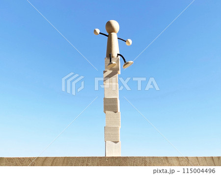 積み上げたキューブの上に乗った人形_真ん中 115004496