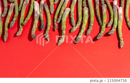 Green asparagus on red background. Vegetable food top view. 115004738
