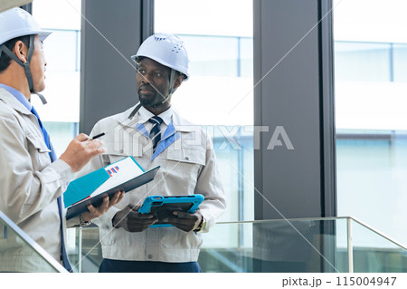 建物の中で会話する多国籍エンジニアのグループ 115004947