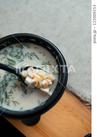 Okroshka with boiled potatoes, egg, ham, fresh cucumber and radish. In a food delivery container. 115009153