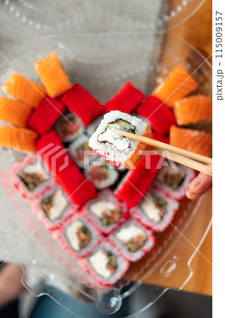 Sushi delivery. Set of rolls in a disposable box. Top view 115009157