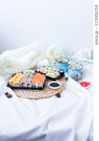 Sushi delivery. Set of rolls in a disposable box on a black background. Top view Sushi delivery. Set of rolls in a disposable box on a black background. Top view 115009158