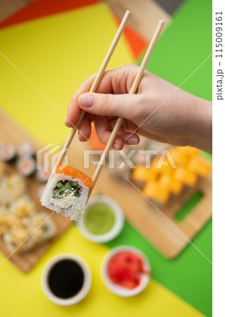 Sushi delivery. Set of rolls in a disposable box on a black background. Top view Sushi delivery. Set of rolls in a disposable box on a black background. Top view 115009161