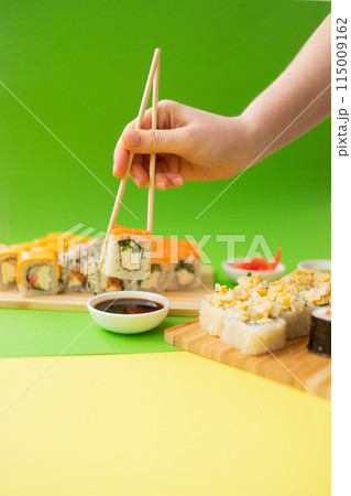 Sushi delivery. Set of rolls in a disposable box on a black background. Top view Sushi delivery. Set of rolls in a disposable box on a black background. Top view 115009162