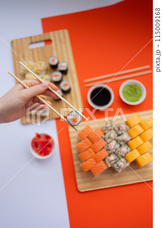 Sushi delivery. Set of rolls in a disposable box on a black background. Top view 115009168
