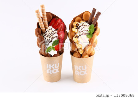 Trendy Hong Kong bubble waffles with ice cream, cream and berries on white wooden background. Copy space 115009369