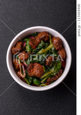 Delicious warm salad with pieces of meat, spinach, tomatoes, salt, spices and herbs Delicious warm salad with pieces of meat, spinach, tomatoes, salt, spices and herbs 115009486
