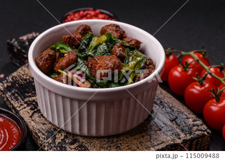 Delicious warm salad with pieces of meat, spinach, tomatoes, salt, spices and herbs Delicious warm salad with pieces of meat, spinach, tomatoes, salt, spices and herbs 115009488