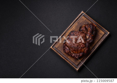 Delicious juicy beef ribeye steak grilled with salt, spices and herbs Delicious juicy beef ribeye steak grilled with salt, spices and herbs 115009587