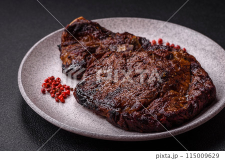 Delicious juicy beef ribeye steak grilled with salt, spices and herbs 115009629