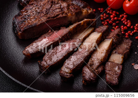 Delicious juicy beef ribeye steak grilled with salt, spices and herbs 115009656