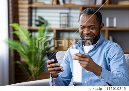A man in his middle age is happily checking his smartphone, holding a receipt in a cozy home with a plant in the background. He seems content and engaged in modern technology A man in his middle age is happily checking his smartphone, holding a receipt in a cozy home with a plant in the background. He seems content and engaged in modern technology 115010246