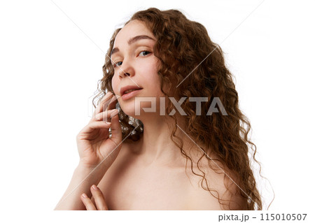 Attractive young woman with brown curly hair. makeup-free face, bare shoulders isolated on white background 115010507
