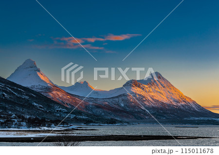 The magical light of the ending polar day on the snowy hills of Lofoten, Norway 115011678