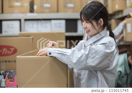 梱包作業する作業着姿の若い女性 115011745