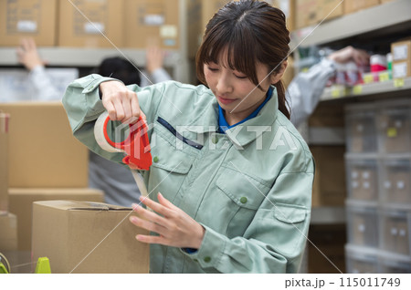 梱包作業する作業着姿の若い女性 115011749
