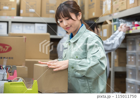 梱包作業する作業着姿の若い女性 115011750