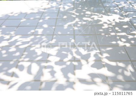 木陰の背景、白いタイルのテーブル 115011765