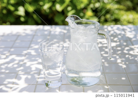 冷たい水、庭の木陰のテーブルにピッチャーとグラス 冷たい水、庭の木陰のテーブルにピッチャーとグラス 115011941