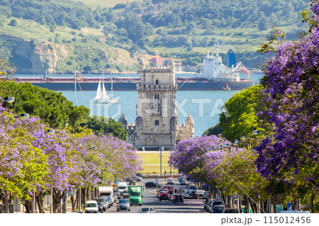 Belem Tower, Jacaranda Blooming Purple Blue Trees, Large Barge and Sailing Boat on Sunny Day. Lisbon 115012456