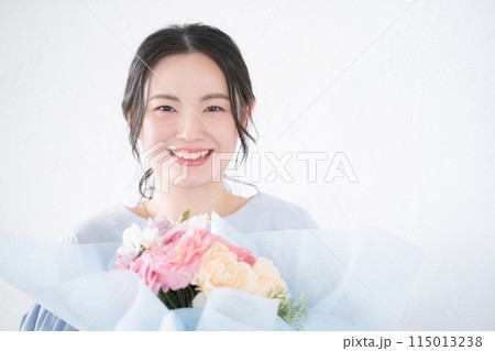 花束のプレゼントを受け取る若い女性　カメラ目線 115013238