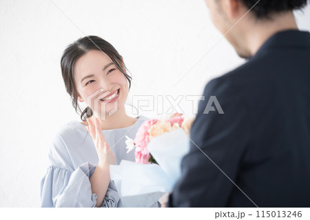 花束のプレゼントを受け取る若い女性と贈る男性の顔無し 花束のプレゼントを受け取る若い女性と贈る男性の顔無し 115013246