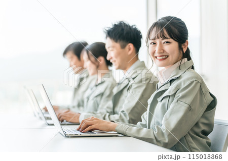 デスクワークする作業着・作業服姿の女性ビジネスウーマン・エンジニア（男女） 115018868