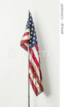 Worn and weathered American flag on a white background. Symbol of resilience and national pride for Independence Day celebrations. 115019287