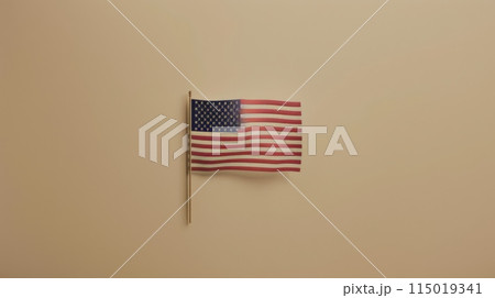 Small American flag on a beige wall. Simple and elegant patriotic display. 115019341