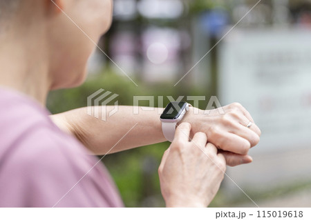 スマートウォッチを見るシニア女性の手元 スマートウォッチを見るシニア女性の手元 115019618