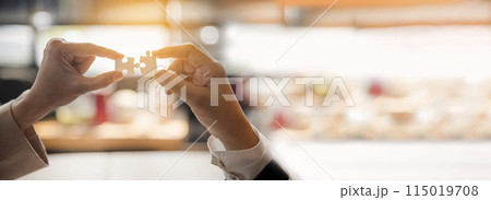 Banner Implement puzzle improve hand holding together solve synergy organize team connection plan trust strategy. Stakeholder business trust teams hands holding jigsaw puzzle synergy with copy space 115019708