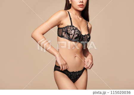 Confident beautiful young asian woman posing in black lingerie on beige background, Perfect body, 115020036