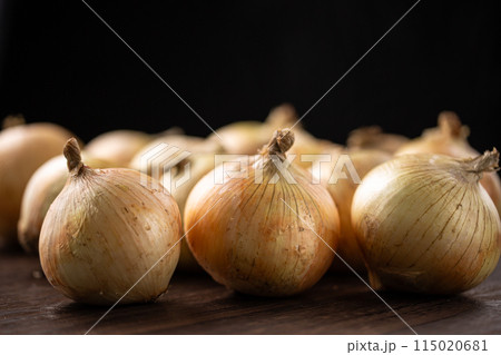 木のテーブルにのせた沢山のタマネギ 115020681