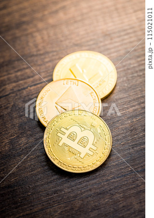 Cryptocurrency coins - Litecoin, Bitcoin, Ethereum on wooden table. Cryptocurrency coins - Litecoin, Bitcoin, Ethereum on wooden table. 115021011