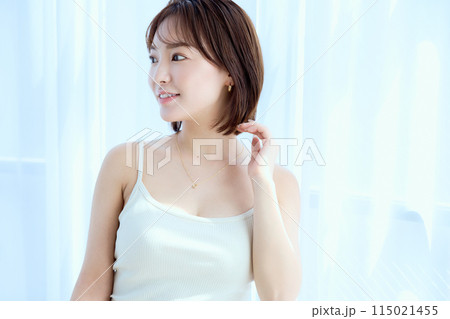部屋の中でレースカーテン越しにくつろぐ女性 部屋の中でレースカーテン越しにくつろぐ女性 115021455