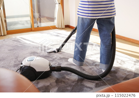 部屋に掃除機をかける女性 部屋に掃除機をかける女性 115022476