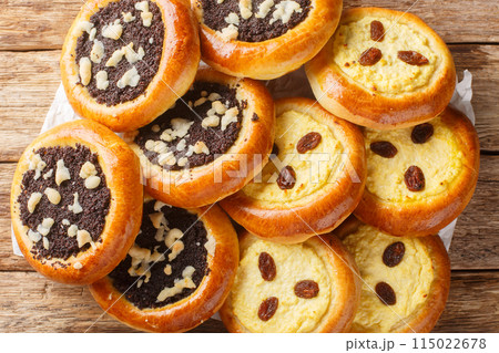 Homemade Czech kolach with traditional filling of cottage cheese with raisins and poppy seeds with streusel close-up on parchment. Horizontal top view 115022678