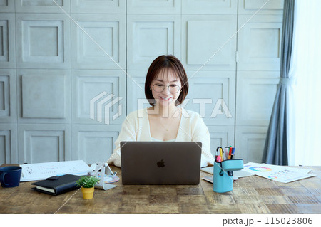 自宅でパソコンに向かって仕事をする女性デザイナー 自宅でパソコンに向かって仕事をする女性デザイナー 115023806